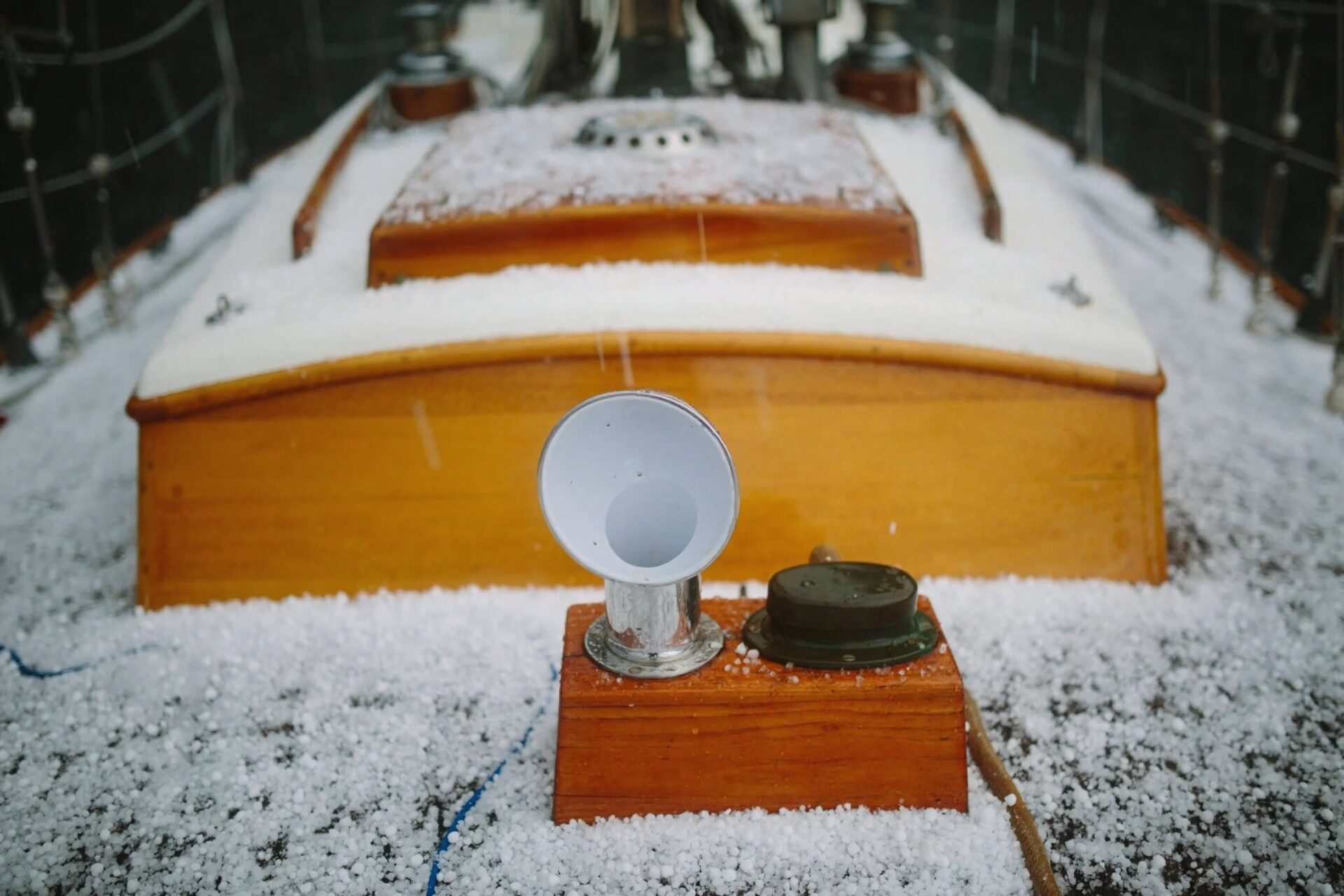 The varnished foredeck of a sailboat dusted with hailstones — a film print